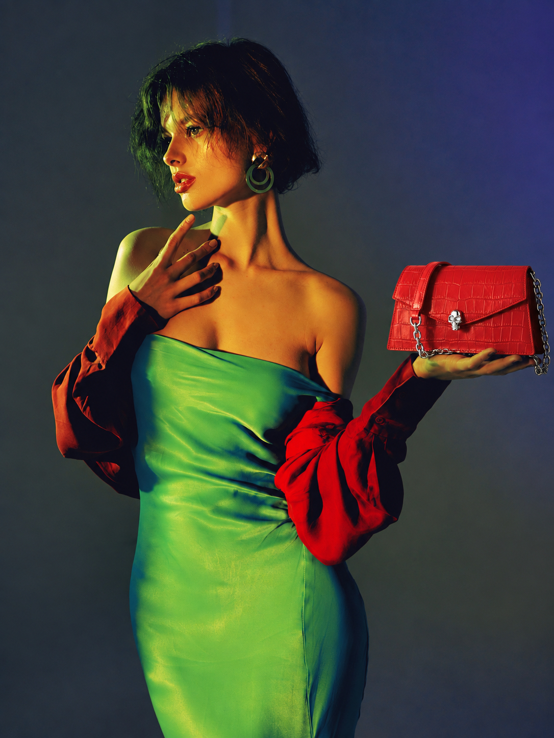 Woman in green and red with a red designer handbag
